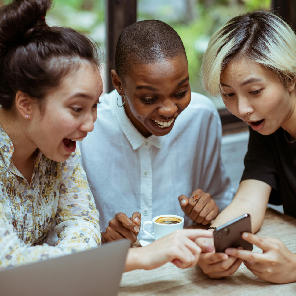 women-see-phone-together-big-smile