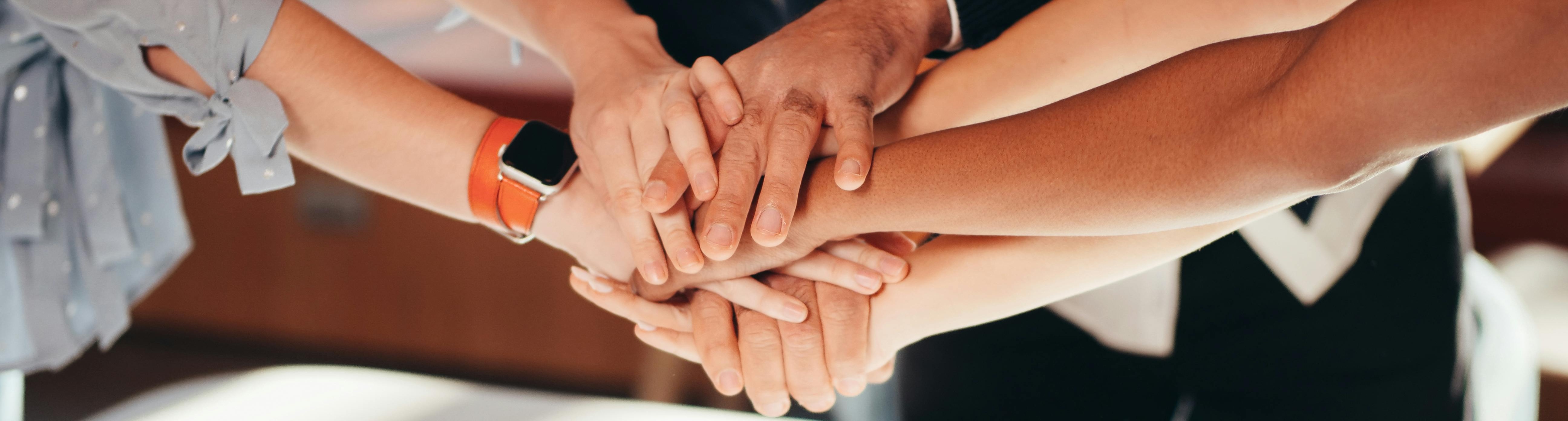 Twee handen die naar elkaar toe reiken.