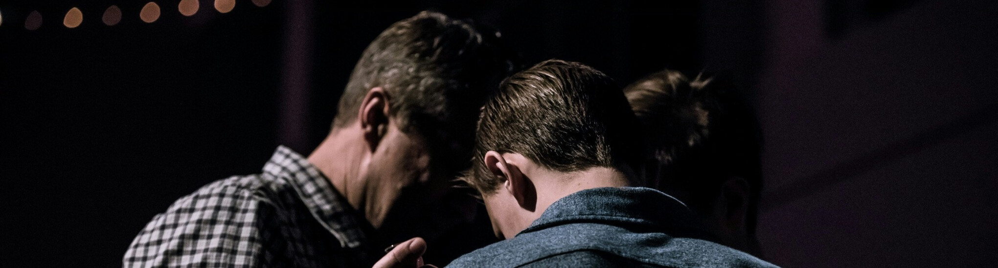 Man praying with a teenage boy